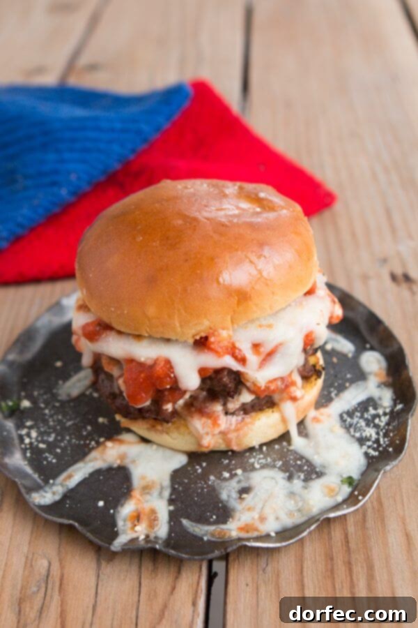 Lasagna Burger with melted cheese, parsley, and parmesan. A stacked Lasagna Burger with a generous topping of melted mozzarella and a sprinkle of fresh parsley and Parmesan cheese, ready to be enjoyed.