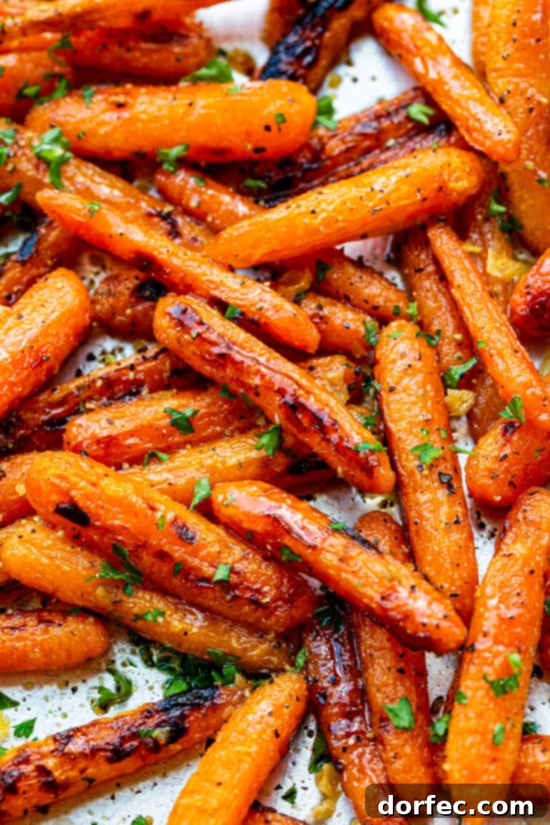 Close-up photo of golden roasted baby carrots, beautifully sprinkled with minced fresh herbs, highlighting their caramelized glaze.