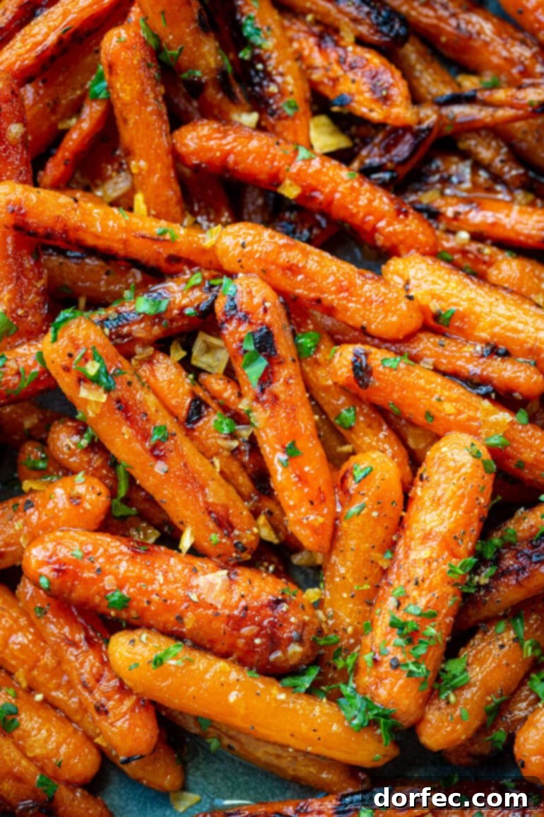 A close-up shot of roasted honey glazed baby carrots, artfully topped with finely chopped parsley and minced garlic, ready to be served.