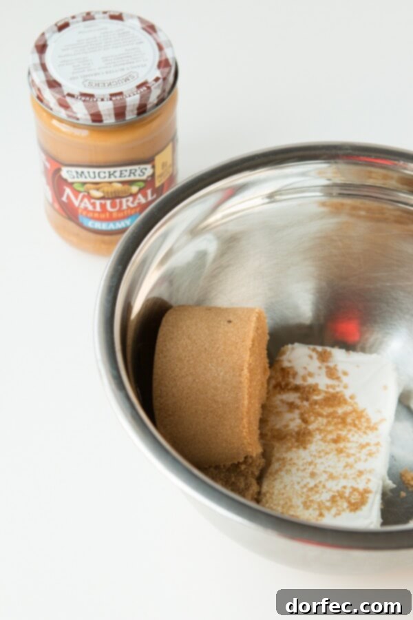 Softened cream cheese in a bowl, a crucial first step for the creamy peanut butter toffee apple dip