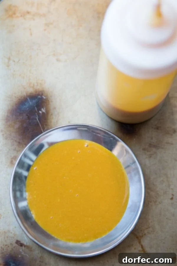 Close-up of a glass jar filled with golden Carolina Mustard BBQ Sauce, showing its thick, rich texture, perfect for grilling.