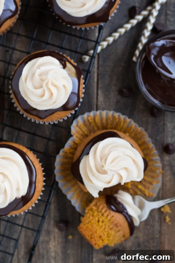 Overhead shot of two Chocolate Covered Pumpkin Cupcakes, highlighting the beautiful layering of chocolate and frosting