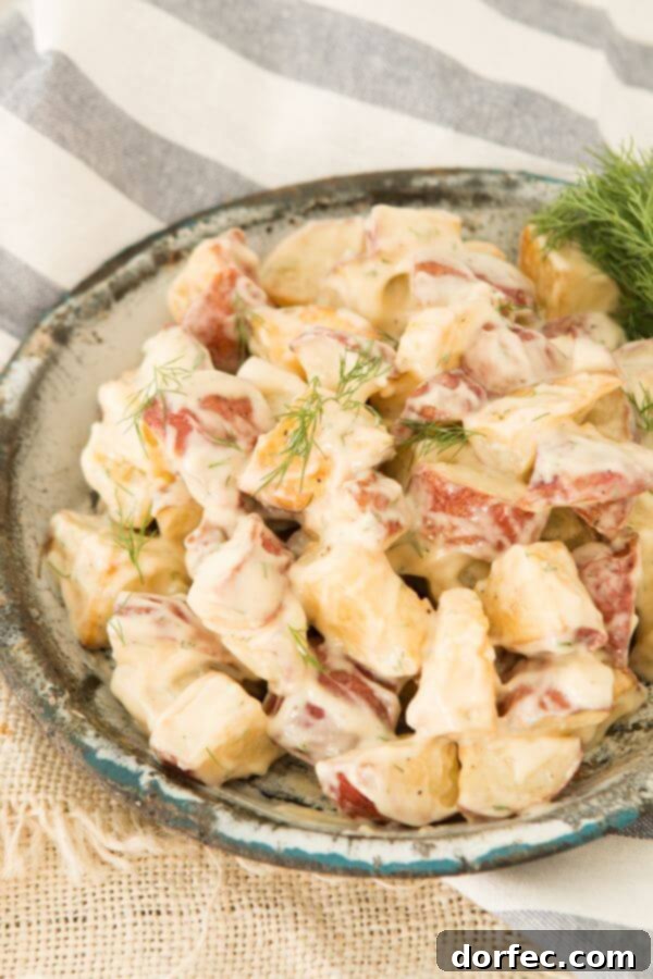 Creamy and Tangy Warm Roasted Potato Salad, a delightful twist on a classic. ohsweetbasil.com