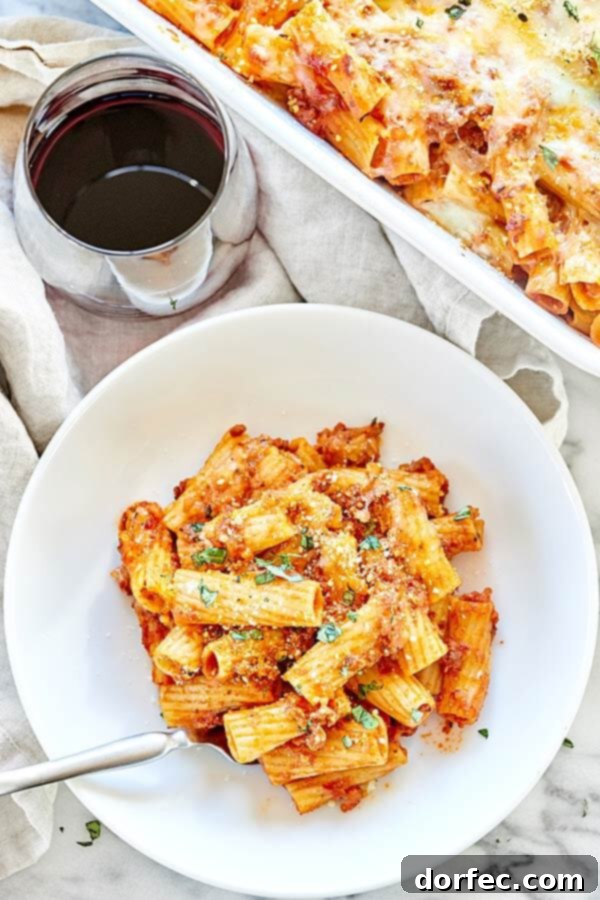 Serving of Spicy Sausage Rigatoni garnished with fresh basil, showcasing the rich sauce, melted cheese, and perfectly cooked rigatoni pasta.