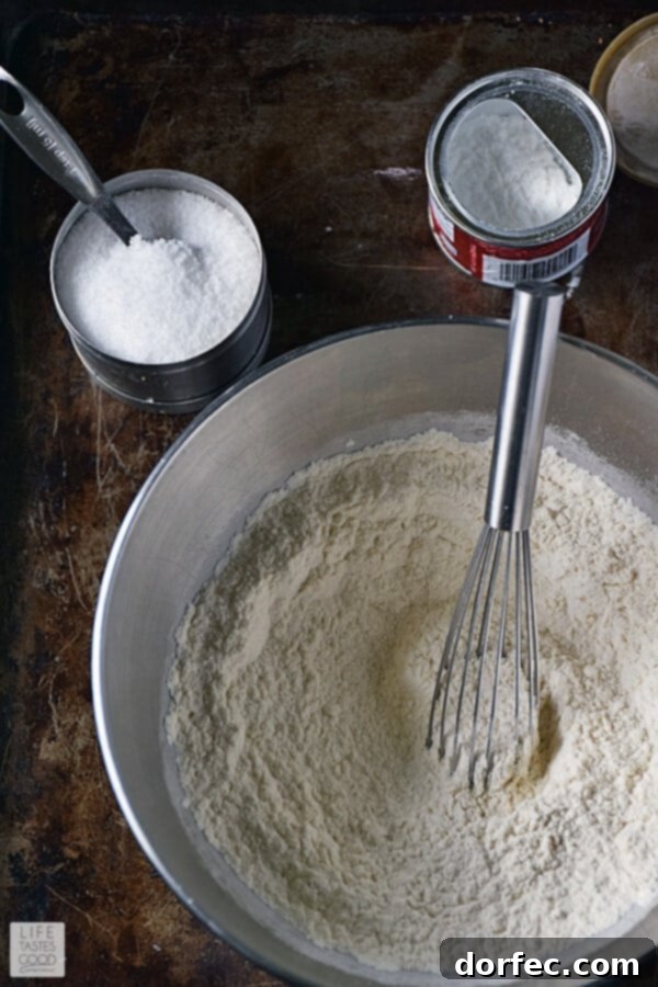 Flour, baking powder, and salt whisked together in a bowl for bundt cake batter.