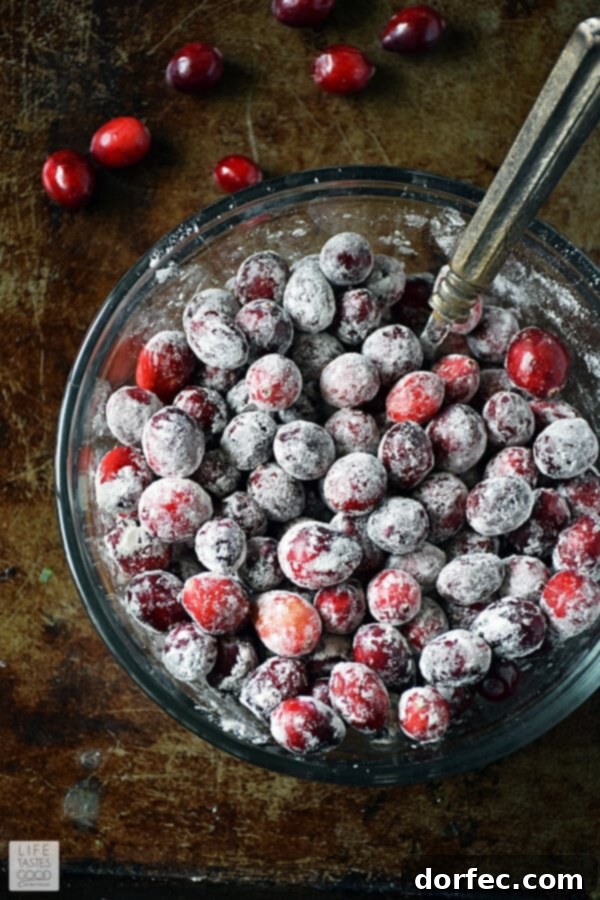 Fresh cranberries lightly tossed with flour in a bowl, prepared for the bundt cake recipe.
