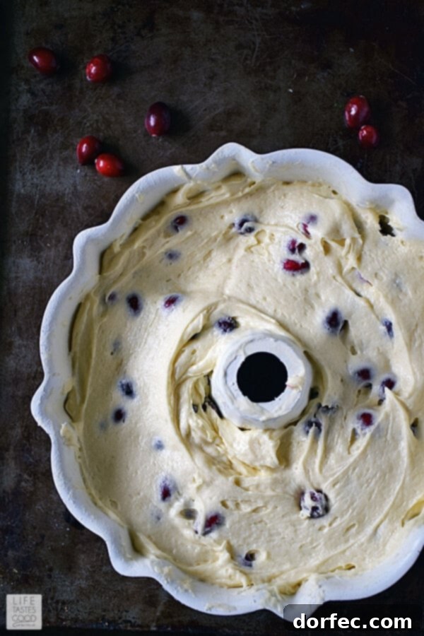 Cranberry Bundt Cake batter evenly spooned into a prepared bundt pan.