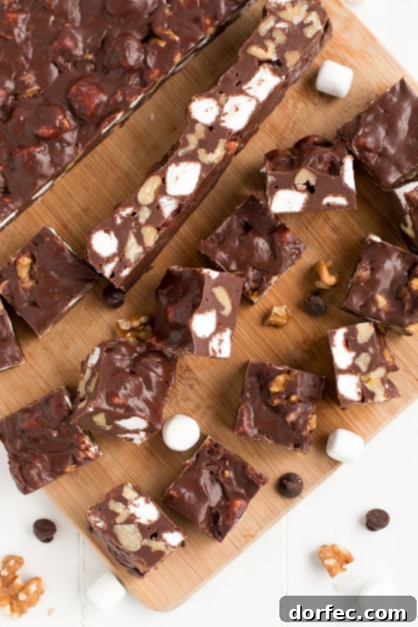 Close-up of freshly cut Rocky Road Fudge squares, showing creamy chocolate, white marshmallows, and crunchy walnuts.