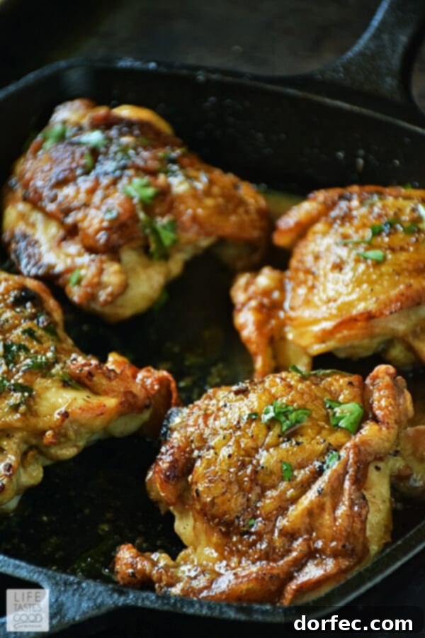 A close-up view of seasoned bone-in, skin-on chicken thighs in a hot cast-iron skillet, skin-side down, beginning to sear to a golden crisp. The seasoning is visible on the chicken, promising a burst of flavor in every bite. This image captures the crucial first step of pan-roasting.