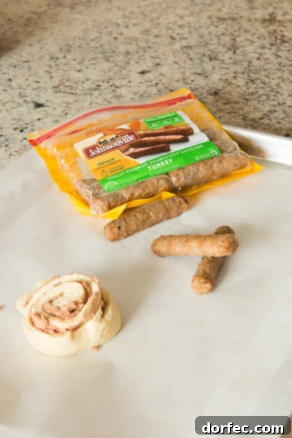 Cinnamon Roll Sausage Poppers 4 A vibrant overhead shot of uncooked cinnamon roll dough ropes ready to be wrapped around breakfast sausages, illustrating the simple preparation steps for this unique breakfast.