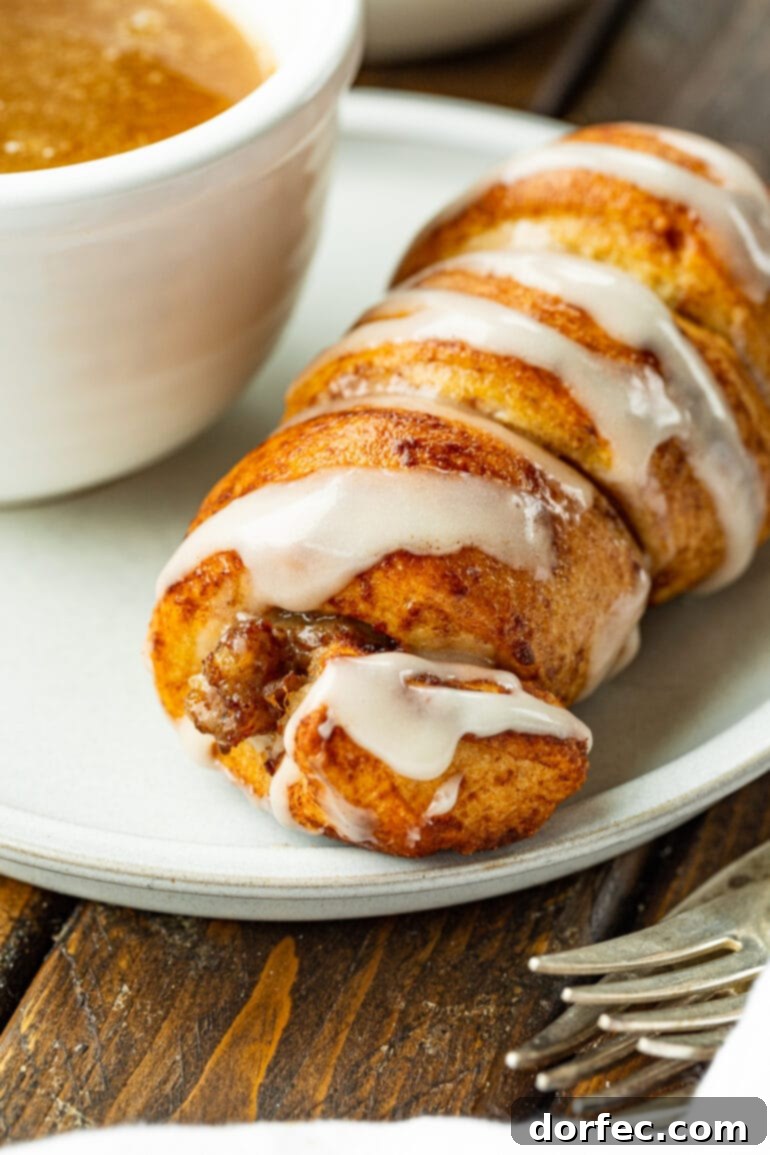 Cinnamon Roll Sausage Poppers 8 A close-up view of a cinnamon roll sausage dunker on a plate, accompanied by a small cup of maple butter sauce, illustrating a champion's breakfast with perfect balance.