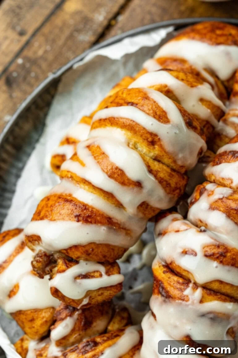 Cinnamon Roll Sausage Poppers 10 A beautiful spread of freshly baked cinnamon roll pigs in a blanket, generously topped with a luscious cream cheese drizzle, perfect for a family breakfast.