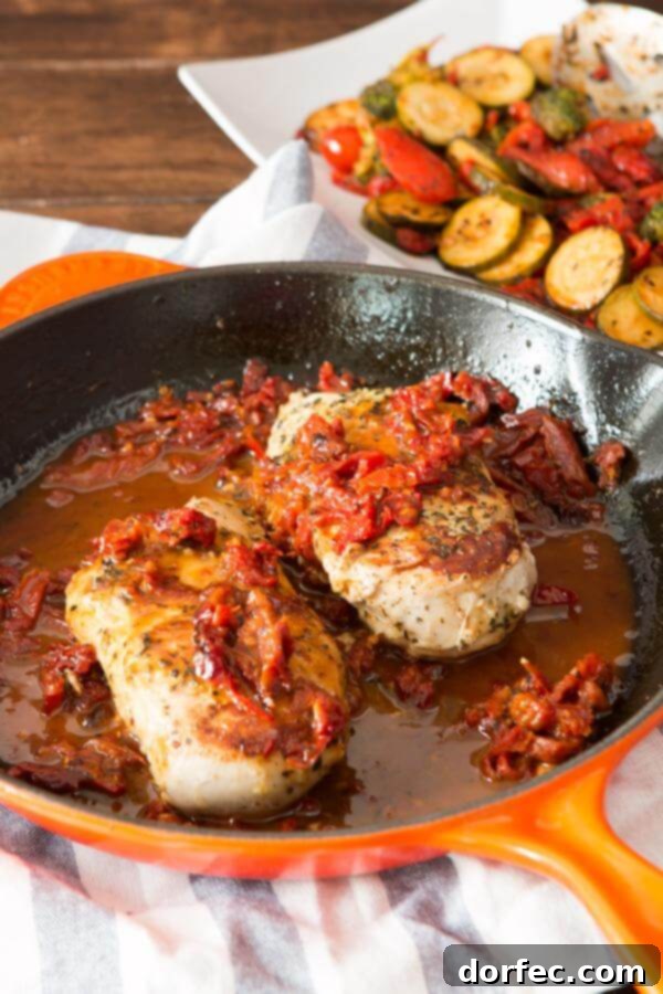 Simple marinated citrus Greek chicken, beautifully plated with sauce and sun-dried tomatoes.