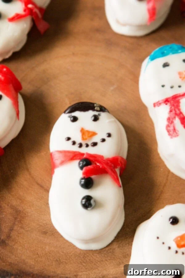 Kids excitedly decorating Nutter Butter Snowmen with white chocolate and fruit roll-ups, perfect for a Christmas activity