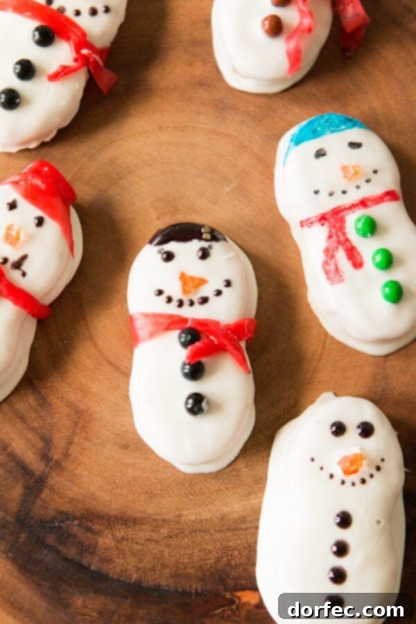 Close-up of a Nutter Butter Snowman, showing details of white chocolate, sugar pearl eyes, and fruit roll-up scarf