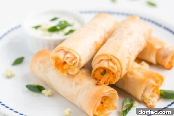 Crispy, flaky, creamy, spicy... these Buffalo Chicken Phyllo Rolls have it all! Close-up of golden-brown Buffalo Chicken Phyllo Rolls arranged artfully, showing their crispy texture and delicious filling.