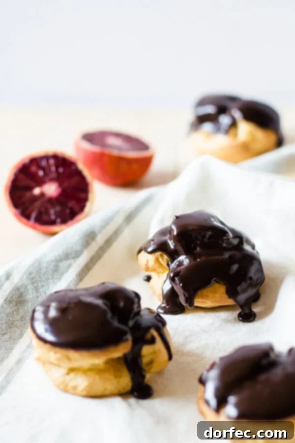 Delicate choux pastry puffs generously filled with sweet blood orange cream and topped with a glistening chocolate ganache.