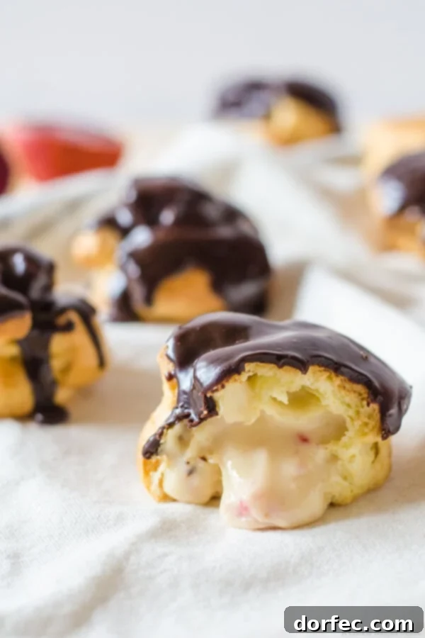 Close-up of a finished blood orange and chocolate cream puff, showcasing the chocolate ganache and fluffy choux pastry.