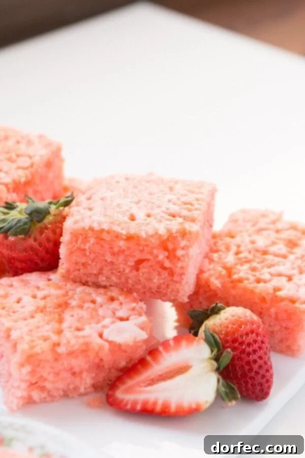 The top of a baked Lemon Strawberry Jello Cake, freshly poked with holes, ready for the lemon glaze to be poured over it.