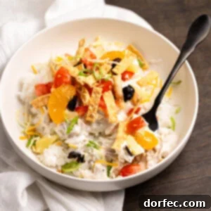 A bowl of Hawaiian Haystacks with creamy chicken sauce and various toppings.