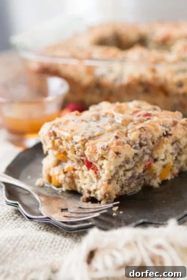 Hearty Southern Sausage Breakfast Cake with Maple Butter Drizzle Close-up of the Southern Sausage Breakfast Cake, showing the golden-baked texture and the colorful bits of sausage, red, and yellow peppers embedded in the fluffy cake, ready to be drizzled with sauce.