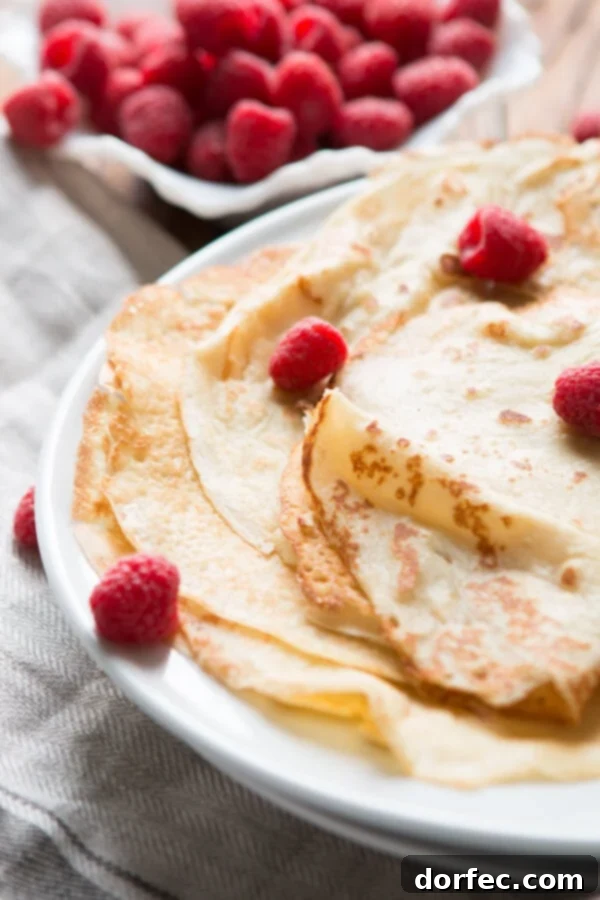 Delicious golden crepes stacked high for serving Delicious golden crepes stacked on a plate, ready to be served for breakfast or dessert.