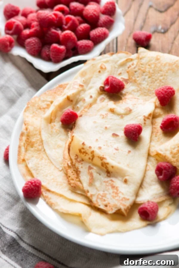 Crepes cooking to a perfect golden hue Close-up of golden crepes cooking in a pan, showcasing their thin and delicate texture.