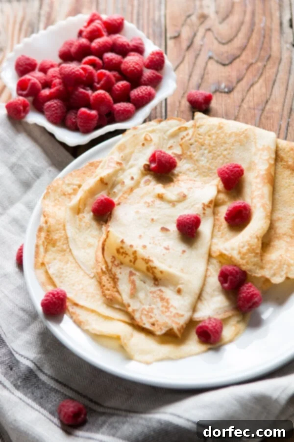 Delicate golden crepes cooling after preparation Freshly cooked golden crepes cooling on a rack, showcasing their flexibility and perfect golden brown edges.