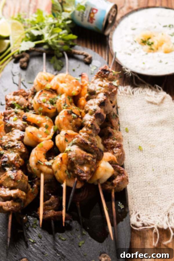 Delicious spicy steak and shrimp kabobs ready to be served with pina colada sauce