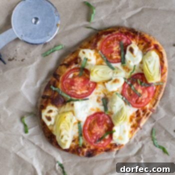 Artichoke A La Mode Flatbread Pizza with healthy artichoke and tomatoes next to a pizza cutter. 