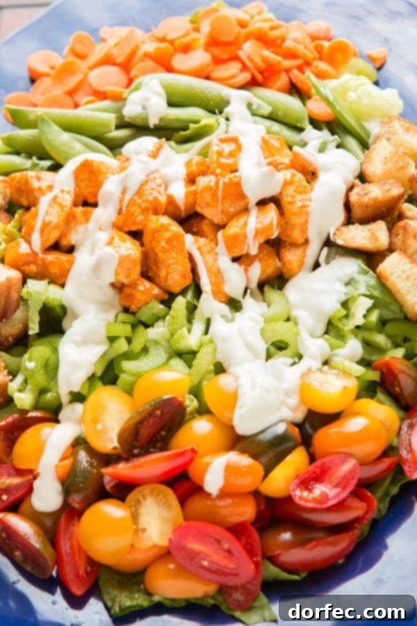 Close-up of a refreshing Buffalo Chicken Salad, showcasing the juicy buffalo chicken, colorful array of fresh vegetables, and creamy blue cheese dressing. ohsweetbasil.com Close-up of a refreshing Buffalo Chicken Salad, showcasing the juicy buffalo chicken, colorful array of fresh vegetables, and creamy blue cheese dressing. ohsweetbasil.com