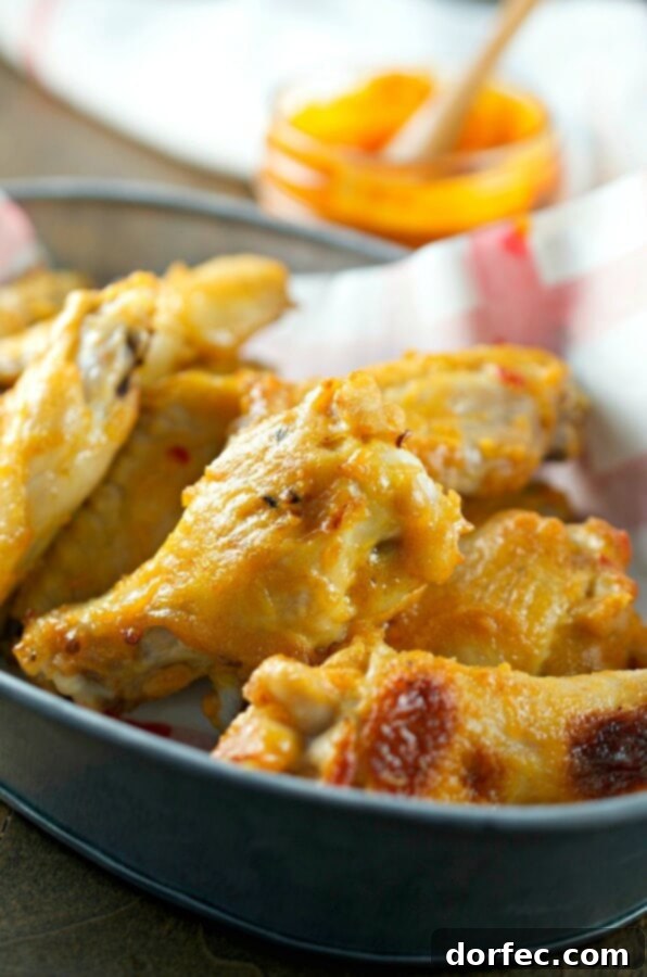 Buffalo Blue: A Zesty Chicken Salad 4 Crispy baked chicken wings tossed in a sweet hot mustard sauce, presented on a plate with fresh greens.