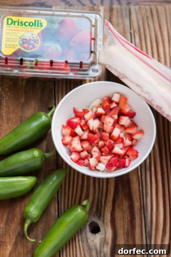 Preparing bacon wrapped strawberry stuffed jalapenos, highlighting the fresh ingredients