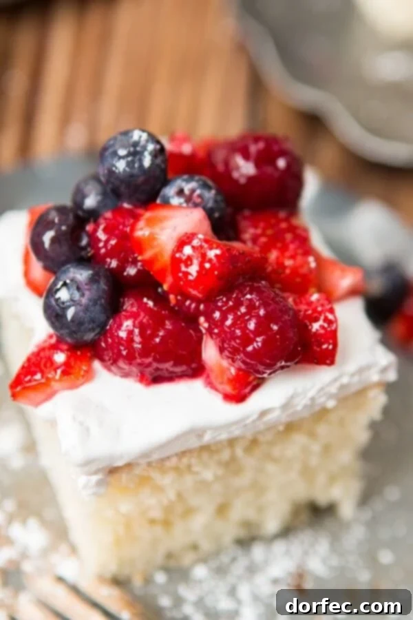 A vibrant display of fresh berries next to the Berry White Yogurt Cake.
