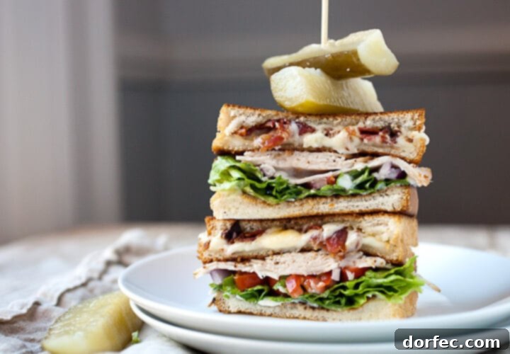 A gourmet grilled cheese club sandwich, stacked with multiple layers of cheese and other fillings, perfectly toasted.