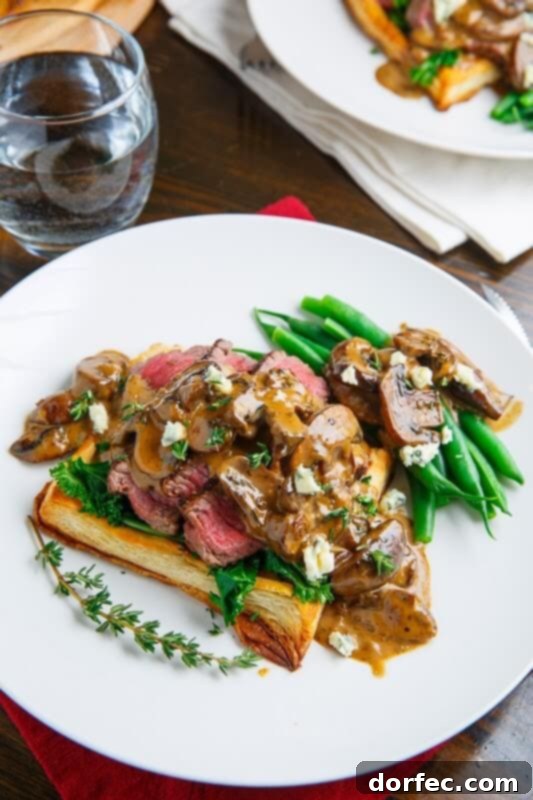 Mini Beef Wellington tarts, featuring puff pastry wrapped around tender beef, served with a rich mushroom and bleu cheese sauce.