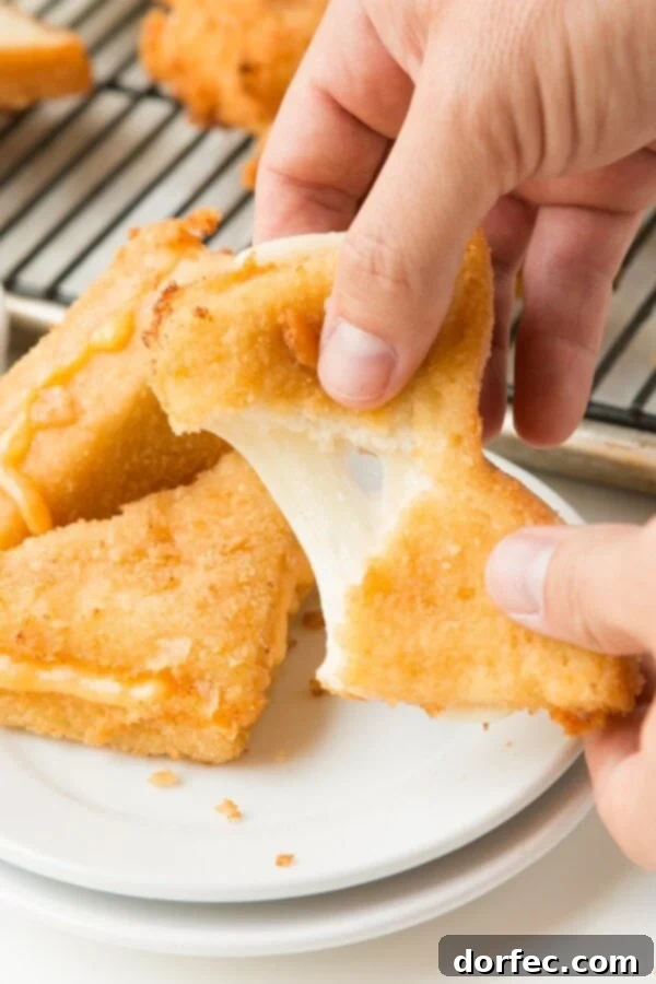 A golden-brown Frenchees deep-fried grilled cheese sandwich, incredibly crispy and oozing with melted cheese.