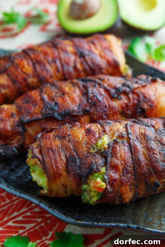 Chicken breasts stuffed with creamy guacamole and wrapped in crispy bacon, a flavorful and creative dish.