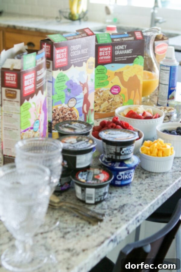 Cinnamon Berry Crisp Yogurt Parfait ingredients laid out for a customizable and fun breakfast for families, featuring Mom's Best Cereal.