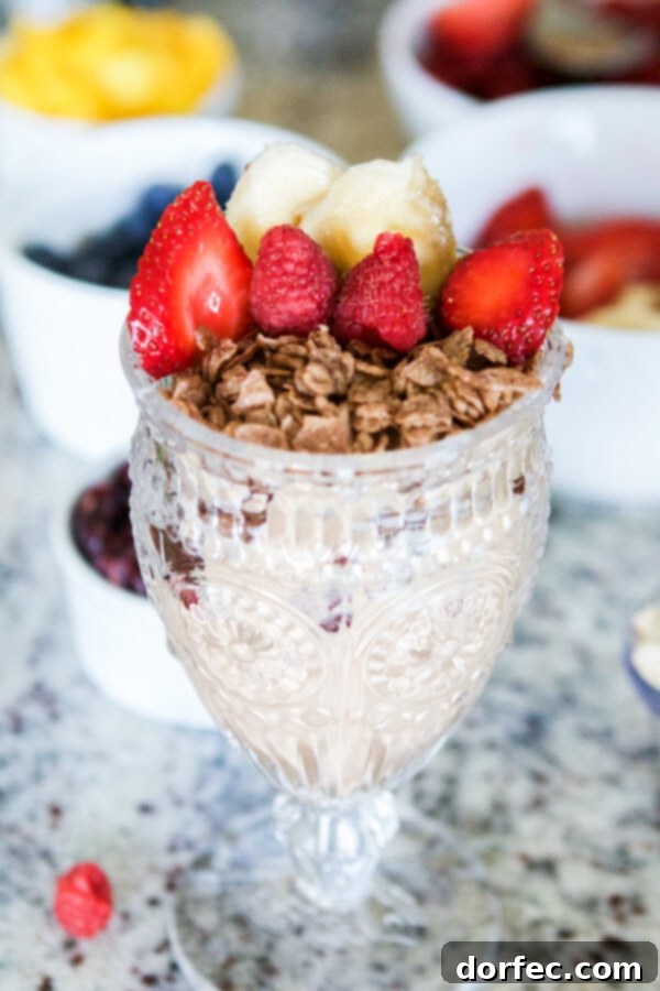 Layered Cinnamon Berry Crisp Yogurt Parfait with Mom's Best Toasted Cinnamon Squares, berries, and drizzled caramel for a gourmet breakfast.