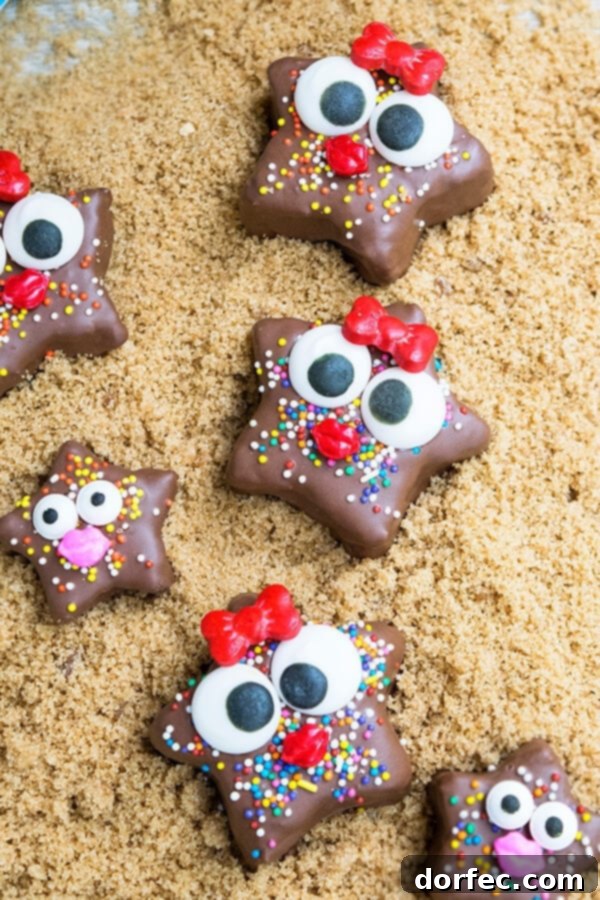 Decorating No-Bake Starfish Snacks Close-up of a child's hand decorating a chocolate starfish snack with colorful sprinkles.