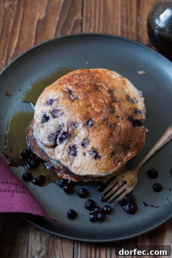 A close-up of a single healthy wild blueberry cottage cheese pancake, showcasing its soft interior with visible blueberries, making it a tempting and nutritious choice.
