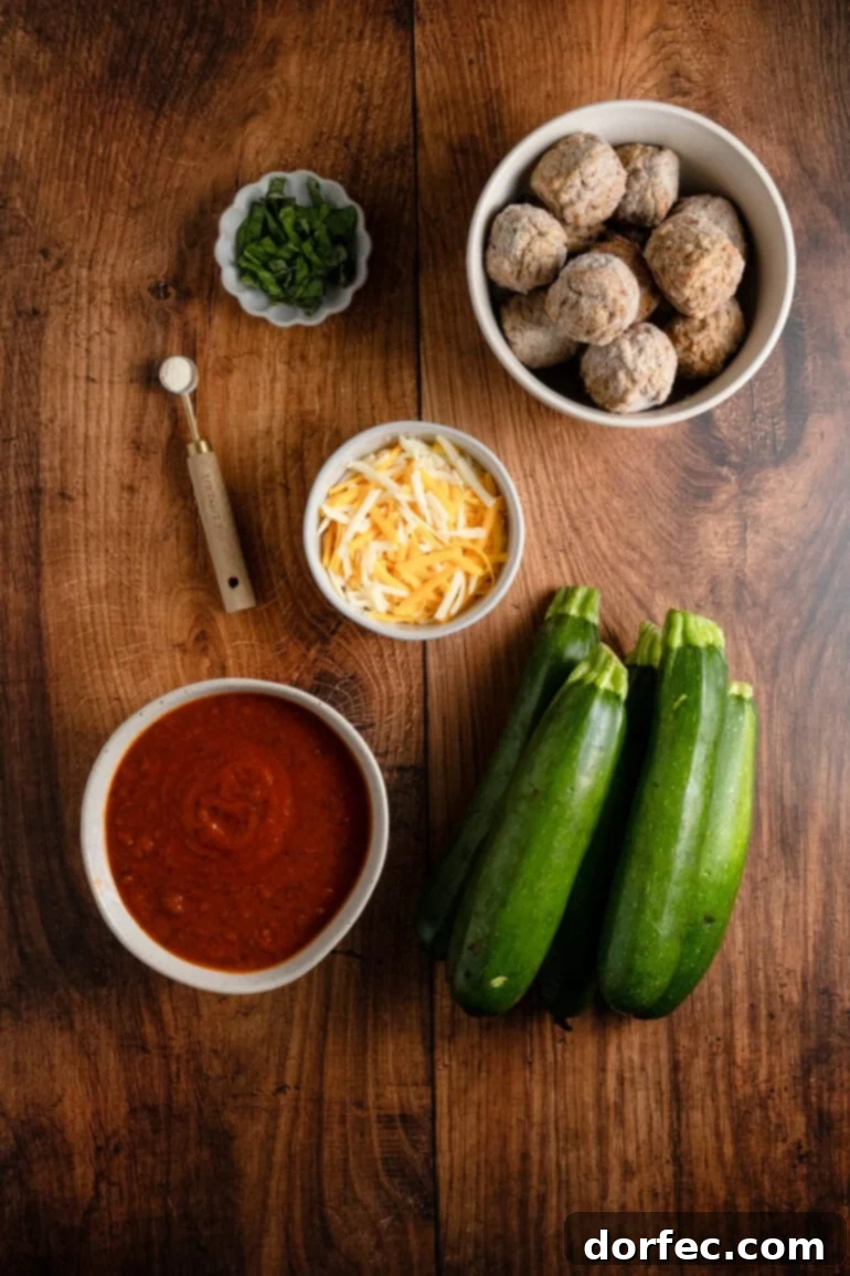 Hearty Cheesy Meatball and Zucchini Skillet 7 bowls filled with maranaria, shredded cheese, frozen meatballs, and basil alongside zucchini and salt.