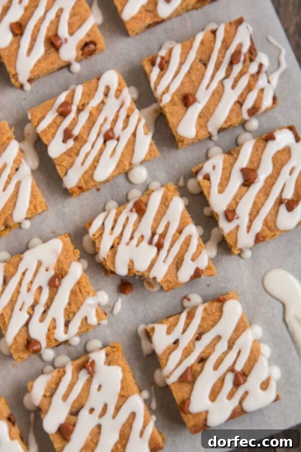 Close-up of a stack of freshly baked Cinnamon Pumpkin Cookie Bars, showcasing their chewy texture and warm fall colors