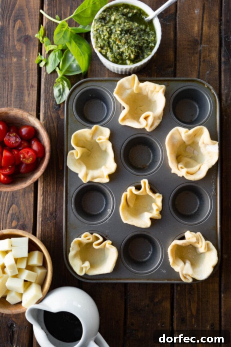 a photo of unbaked puff pastry rounds pressed into a mini muffin pan