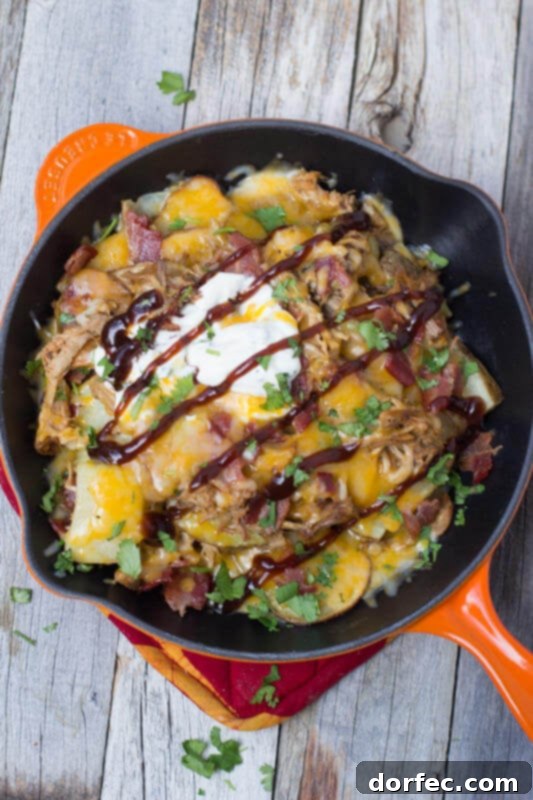 Hearty Tailgator Nachos loaded with savory BBQ pork, perfectly roasted potatoes, crispy bacon, and an abundance of melted cheese.