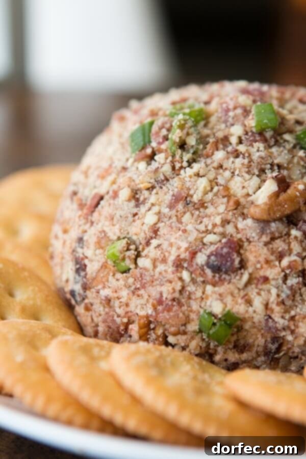 A savory BBQ Bacon Cheese Ball, covered in crispy bacon bits and green onions, served with crackers.