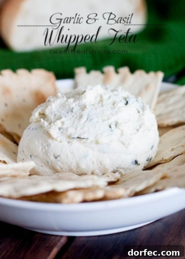 Creamy Garlic and Basil Whipped Feta Dip in a bowl, garnished with fresh basil leaves and a drizzle of olive oil, ready for dipping.