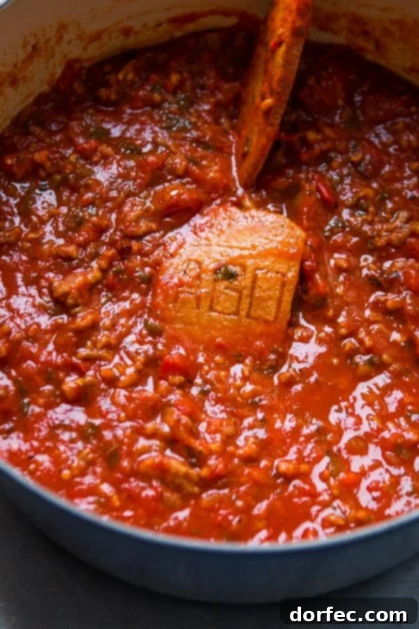homemade spaghetti sauce in dutch oven with parmesan rind cooking in it