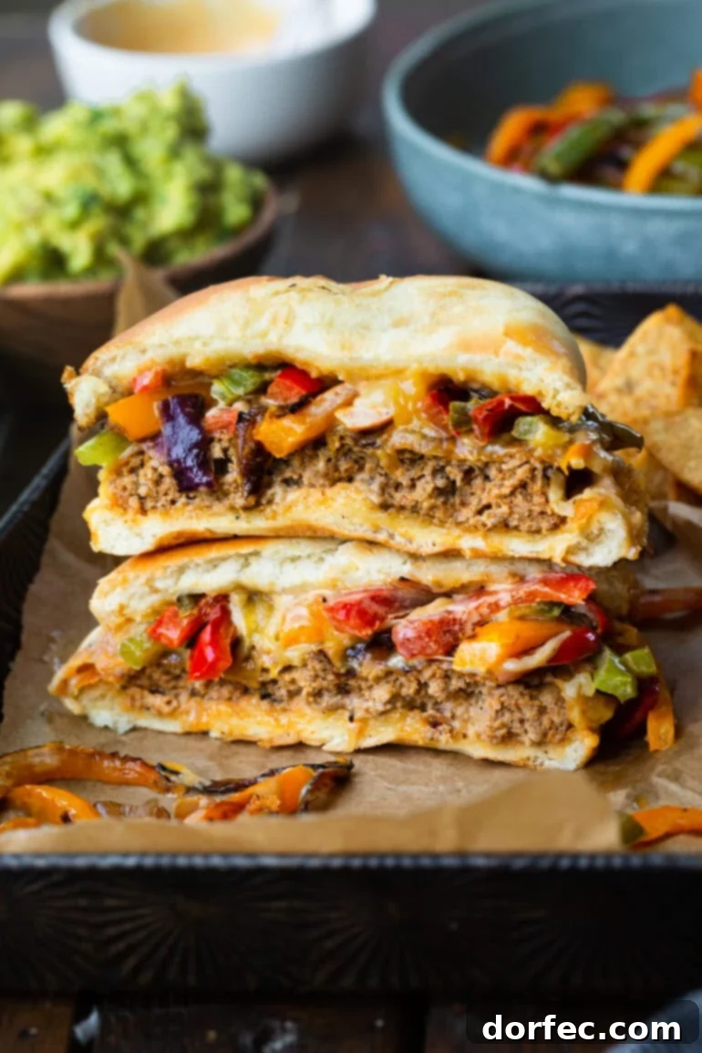 Sizzling Mexican Fajita Burgers 2 A perfectly cooked Mexican fajita burger, sliced in half to reveal its juicy interior, stacked with sautéed onions and peppers, ready to be devoured.